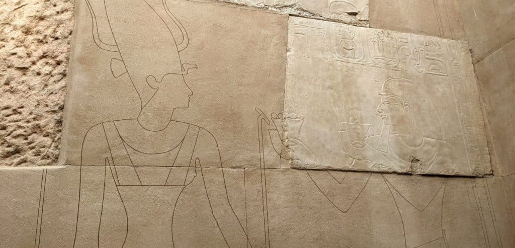 A carving on a temple wall next to a drawing showing what it would have looked like originally