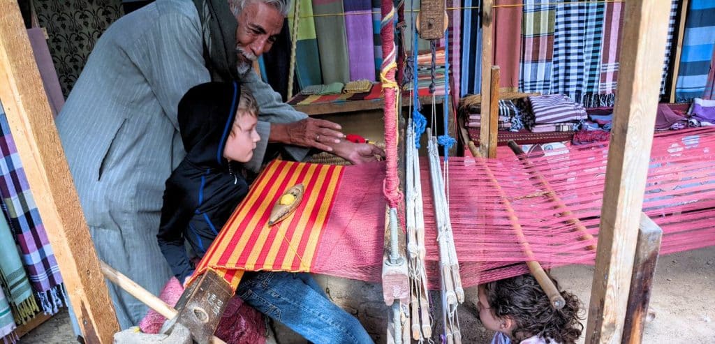 An Egyptian man showing my kids how a loom works