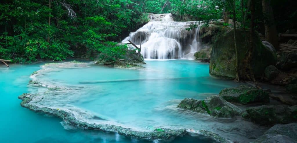 Turquoise blue water below a waterfall in Erawan National Park.