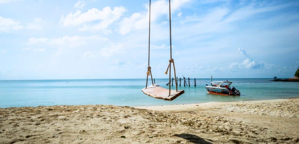 A swing sits empty on a sandy beach in Koh Samet.
