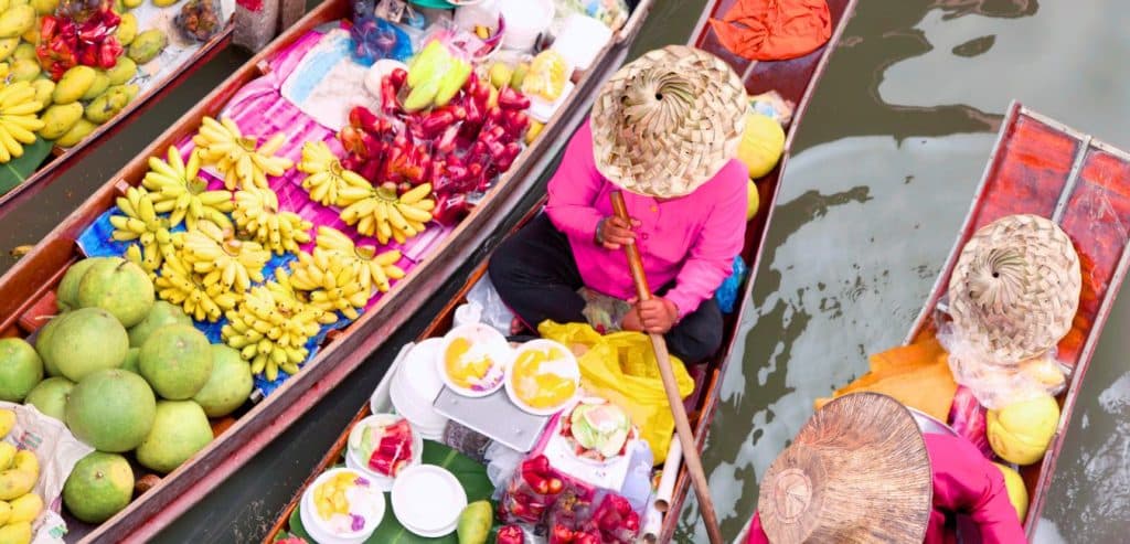 Women with brightly colored food to sell in their boats on the river.