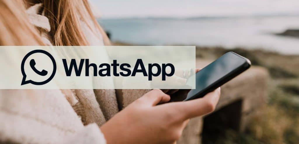 WhatsApp Logo over picture of a person texting