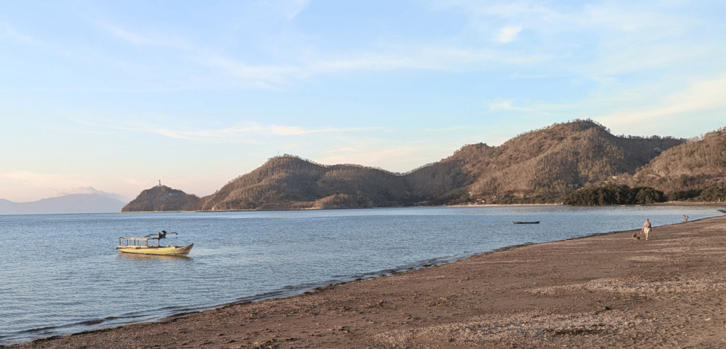 A quiet beach with mountains in the background