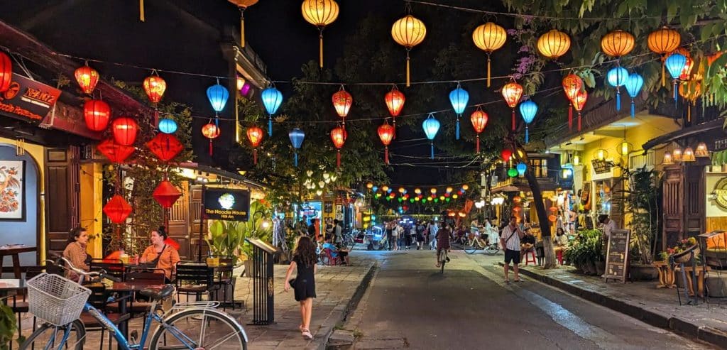 Colorful lanterns strung across a street in Hoi An at night time.