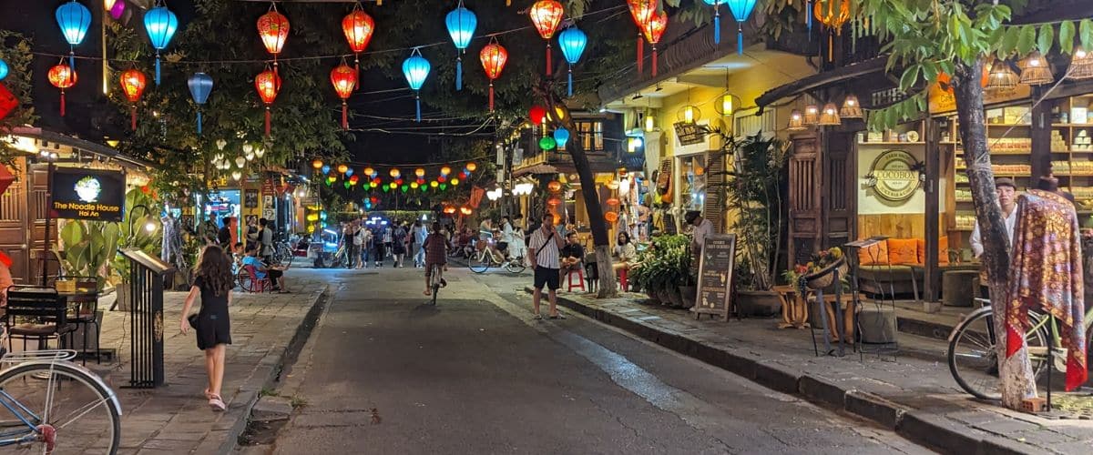 Colorful lanterns strung across a street in Hoi An at night time.