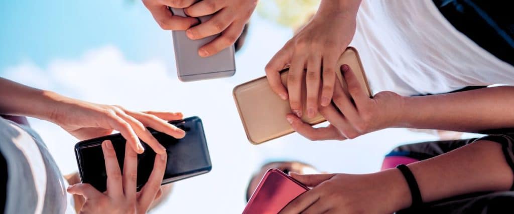 A circle of friends looking at their phones