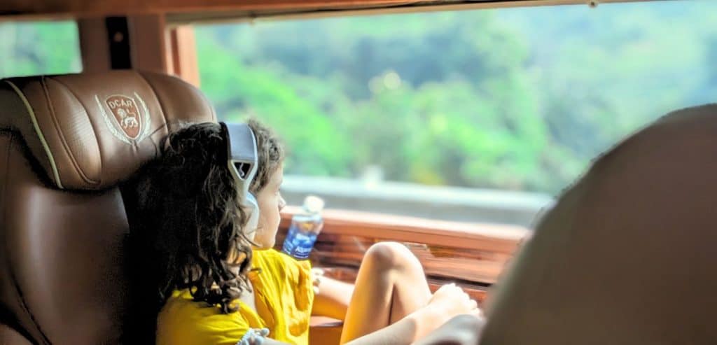 A girl listening to headphones and looking out the window